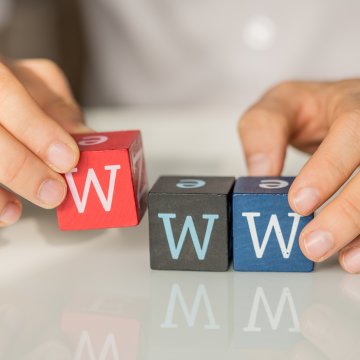 justhost web hosting service review hands holding colored cubes with w letter on them www